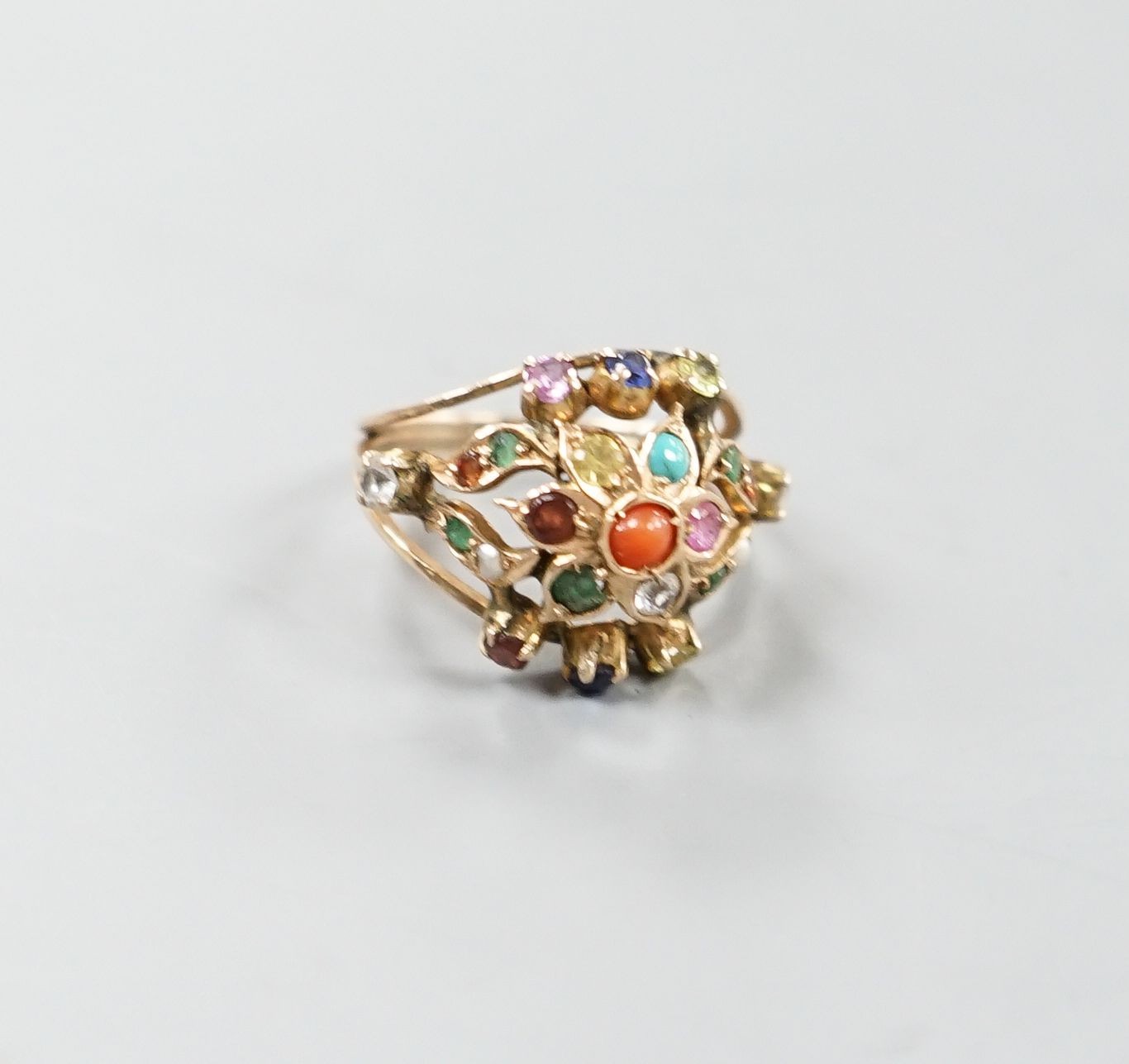 An early 20th century Arts & Crafts yellow metal and multi gem set set cluster ring, size H/I, gross weight 3.6 grams.